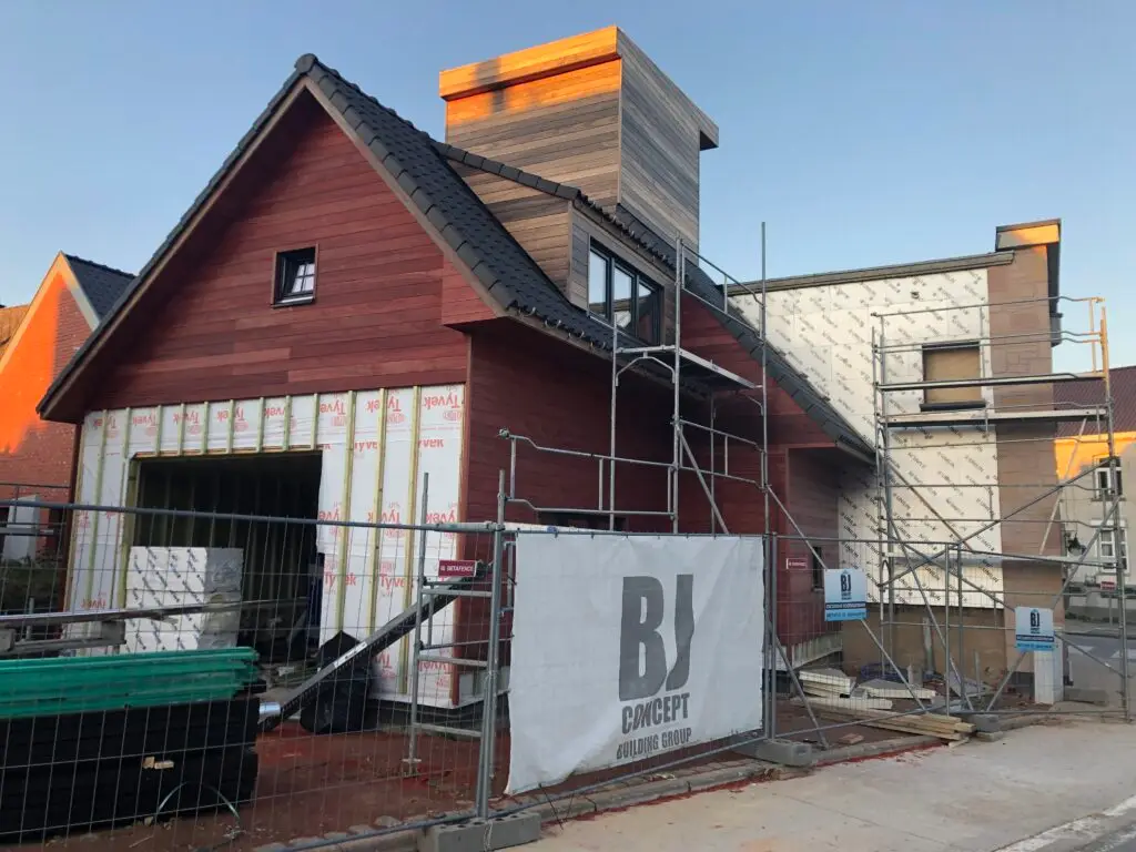Plaatsing van houten gevelbekleding op de houtskelet aanbouw in Brakel