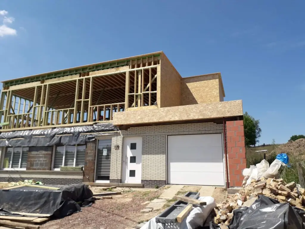 Dakbalken en houten stijlen boven de bestaande woning in Zottegem