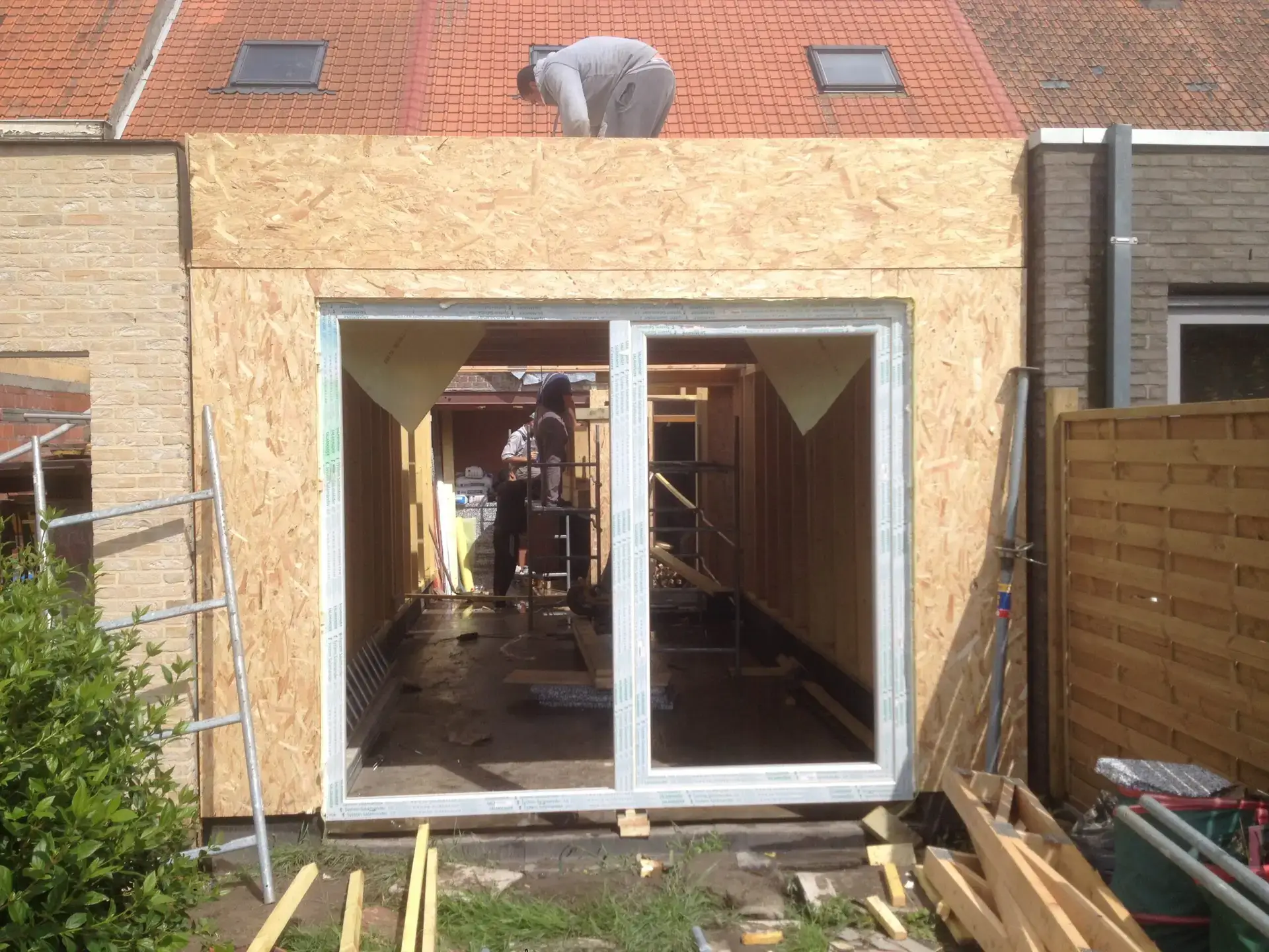 Aanbouw in Drongen met OSB-gevelbeplating en een groot raam tijdens de uitvoering