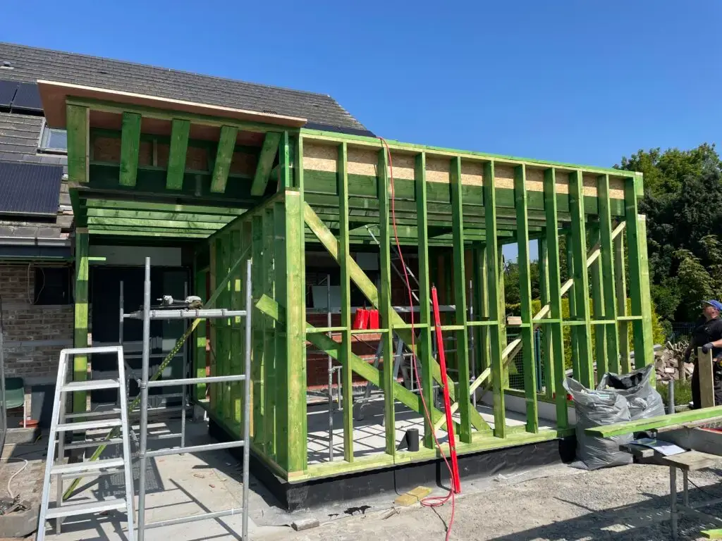 Houten wandstijlen en dakconstructie van de nieuwe praktijkruimte in Merelbeke