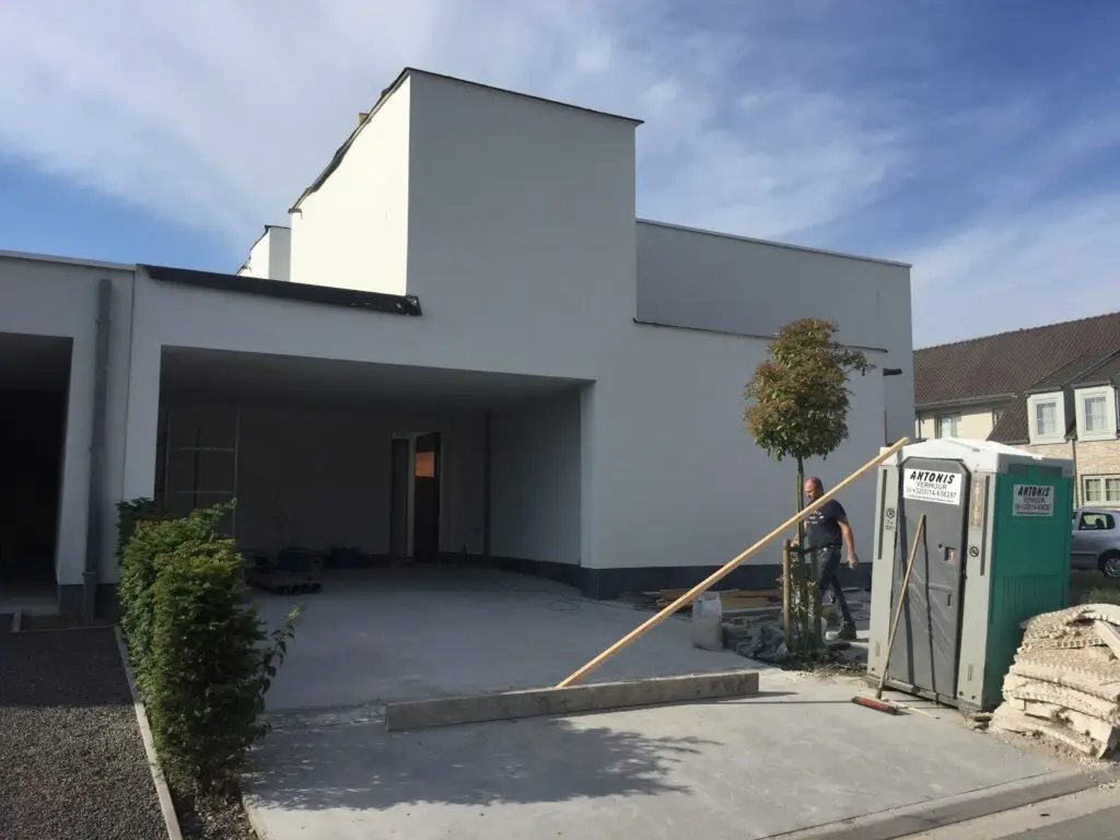 Aanbouw in Waregem met witte crepigevel naast de bestaande woning