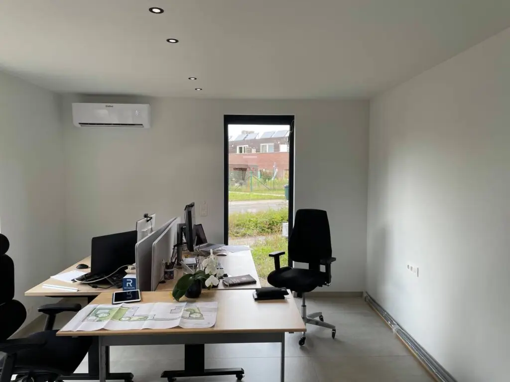 Bureaus en beeldschermen in de afgewerkte kantoorruimte aan huis