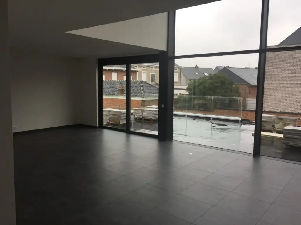 Leefruimte met hoge raampartij in de nieuwbouwwoning in Denderleeuw