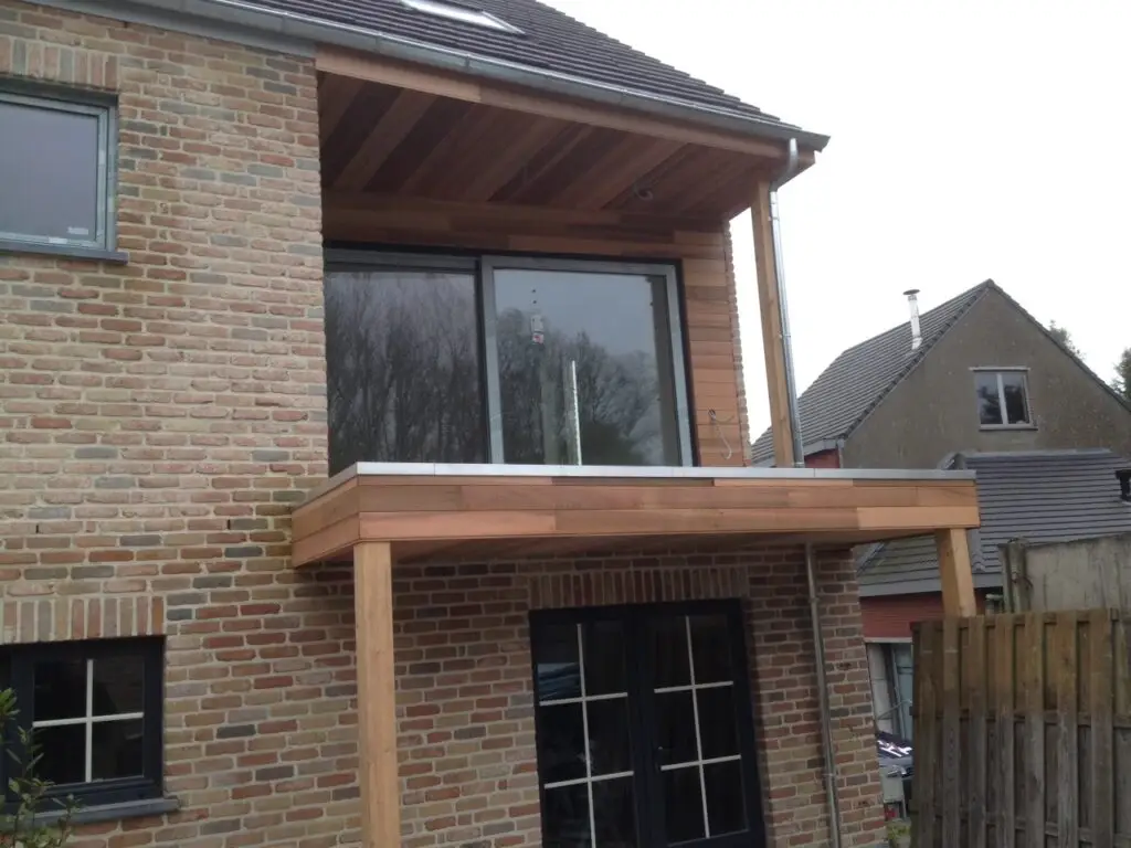 Achtergevel van de woning in Kerksken met grote ramen en een houten terras bij de extra verdieping