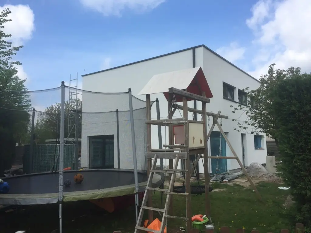 Woning met extra verdieping en lichte crepigevel, gezien vanuit de tuin in Mariakerke