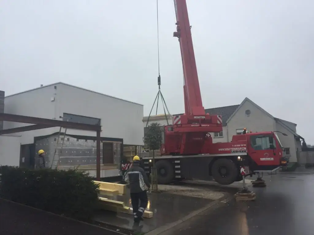 Overzicht van de woning in Waregem met kraanwagen tijdens de montage van de aanbouw