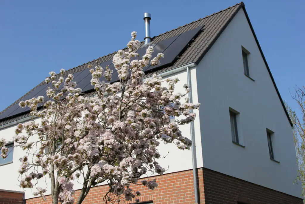 Afgewerkte woning met extra verdieping in Ressegem, met witte gevel en hellend dak