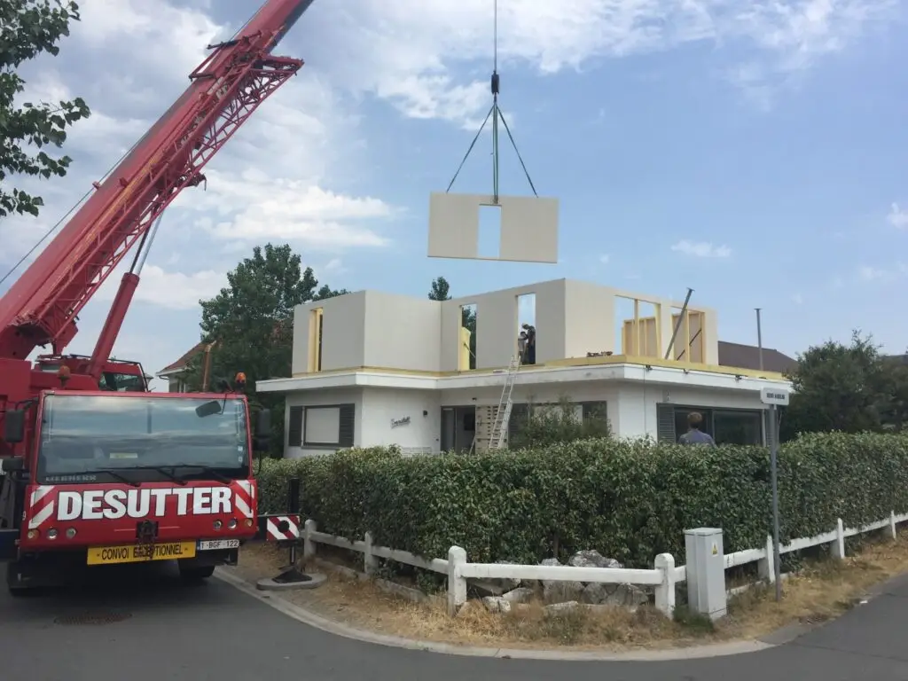 Prefab houtskeletwand aan de kraan voor de extra verdieping in Koksijde