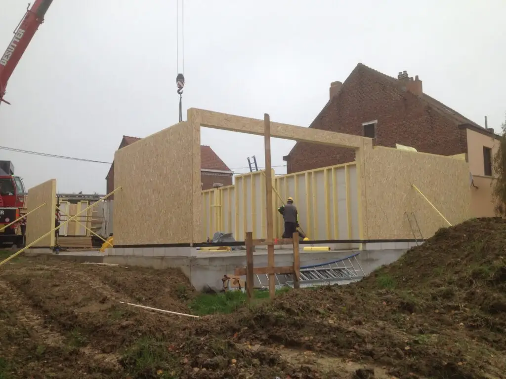 Gelijkvloerse houtskeletwanden met brede raamopening tijdens de bouw in Dilbeek