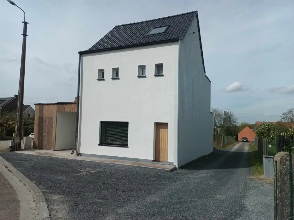 Gerenoveerde woning met witte crepi en houten carport in Semmerzake, Gavere
