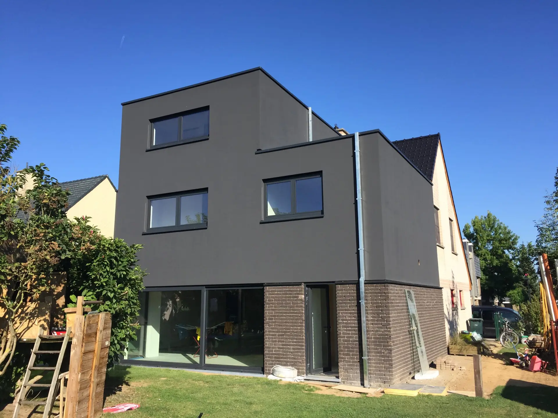 Afgewerkte houtskelet aanbouw met grijze crepi in Lierde