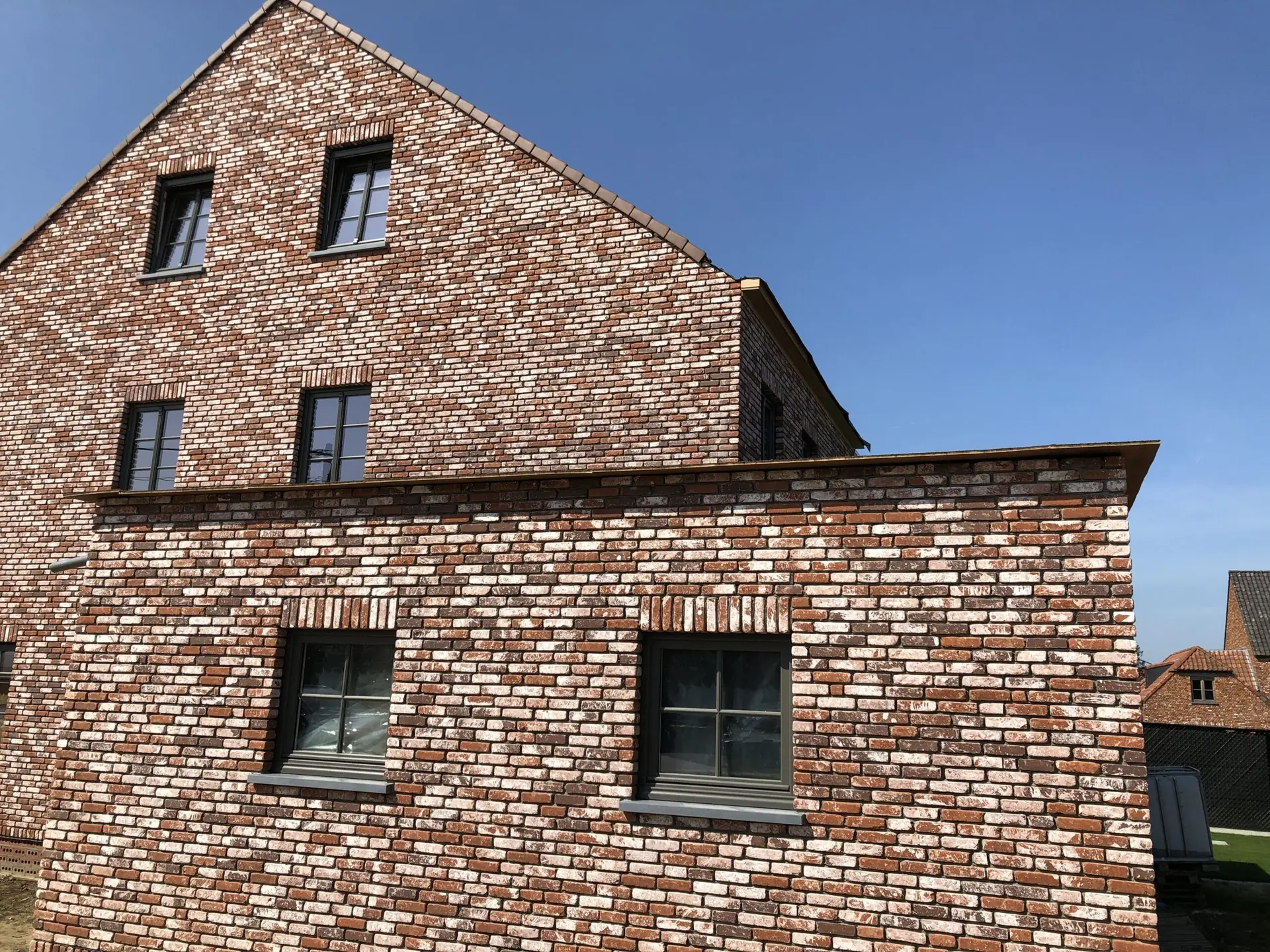 Bakstenen gevel met zadeldak van de rustieke nieuwbouwwoning in Haaltert