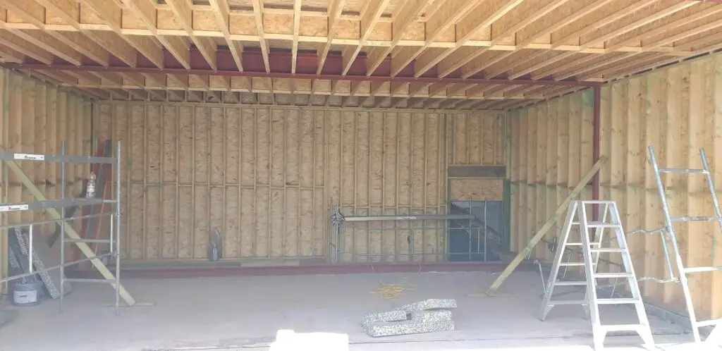 Open houtskeletstructuur bij De Kring in Oudenaarde, klaar voor isolatie tussen de balken