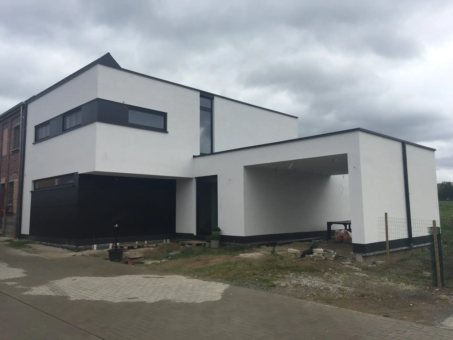 Moderne houtskeletwoning in Heldergem met witte crepi en donkere Trespa-accenten