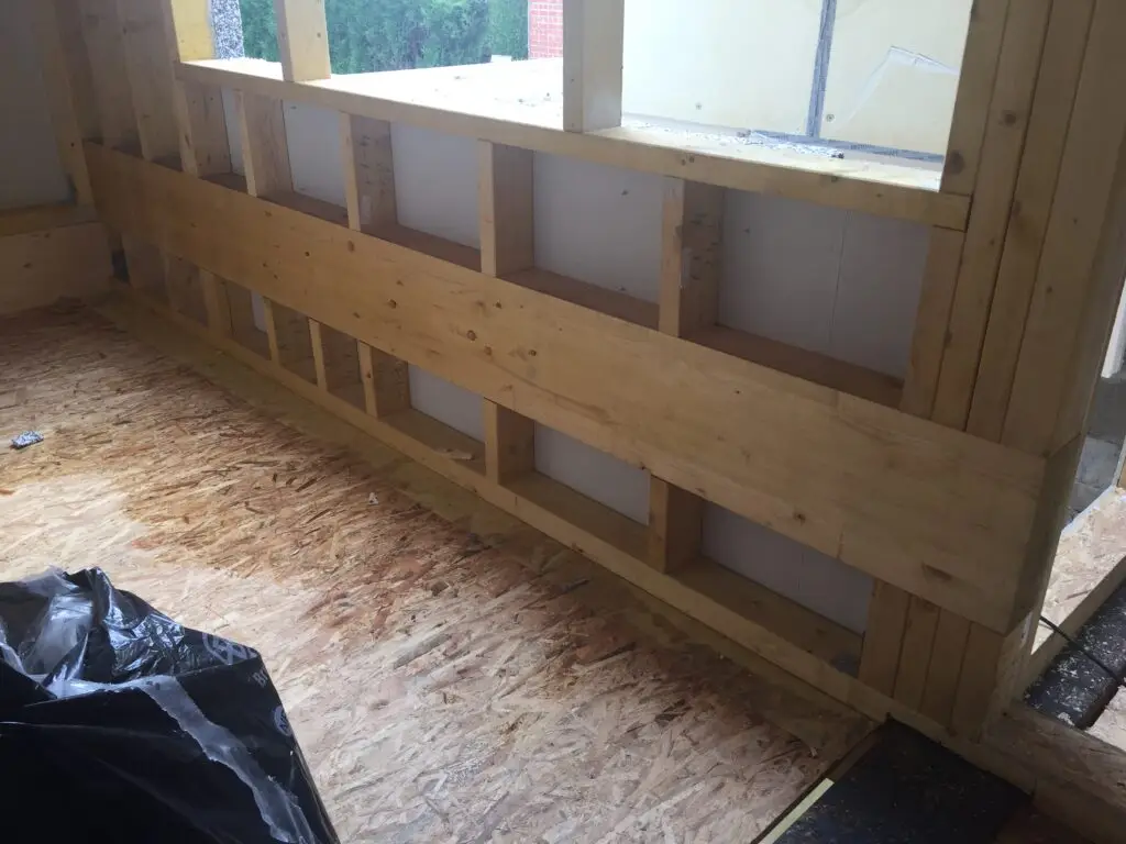 Houten wandconstructie onder de ramen van de nieuwbouw in Halle
