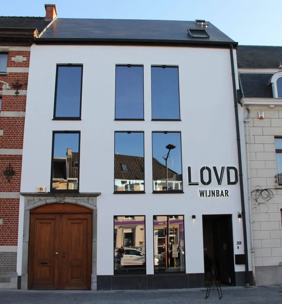 Witte voorgevel met hoge ramen en het opschrift LOVD Wijnbar in Ninove