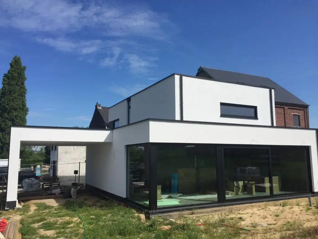 Tuinzijde van de woning in Heldergem met witte crepi en grote hoekramen