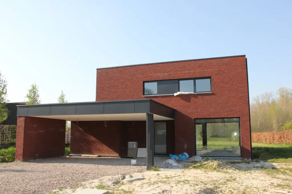 Moderne nieuwbouw in houtskeletbouw met rode gevelsteen en donkere gevelaccenten