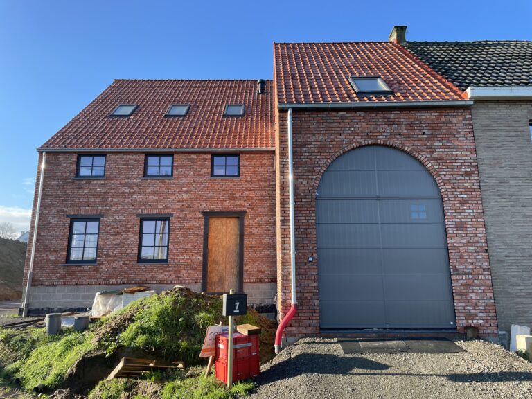 een nieuwbouw in landelijke stijl met hoge garagepoort.