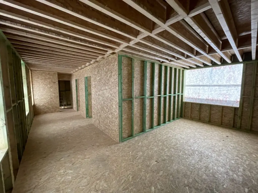 Houten stijlen, dakbalken en OSB-platen binnen in de nieuwe verdieping in Zottegem