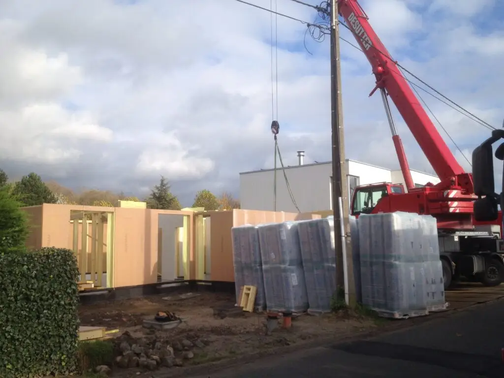 Plaatsing van prefab houtskeletpanelen met een kraan bij de nieuwbouw in Boortmeerbeek