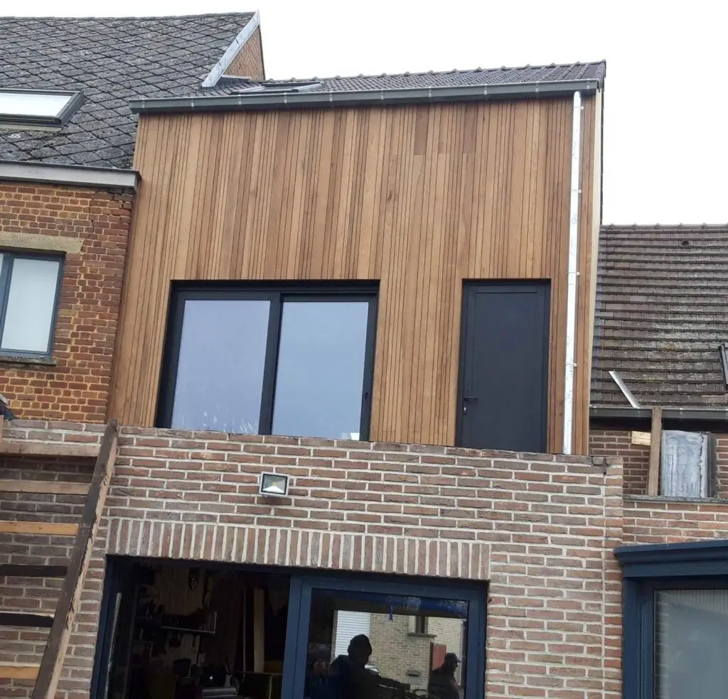 Achtergevel van de optopping met verticale thermo fraké planchetten, raam en deur