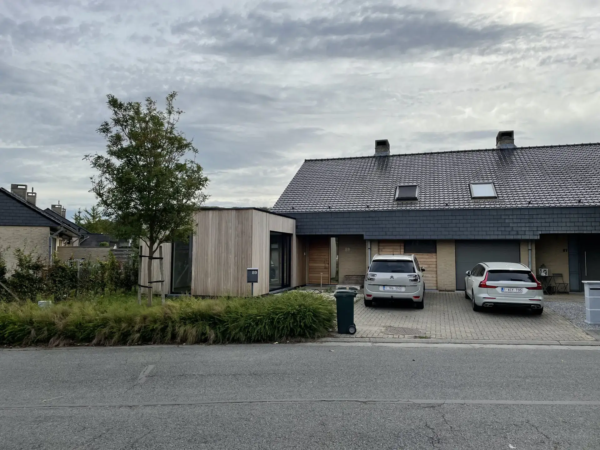 Houten kantooruitbreiding naast de bestaande woning gezien vanaf de straat