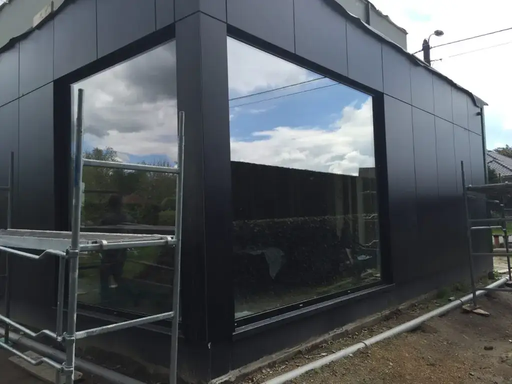 Gelijmde Trespa-gevelbekleding rond het hoekraam van de woning in Boortmeerbeek