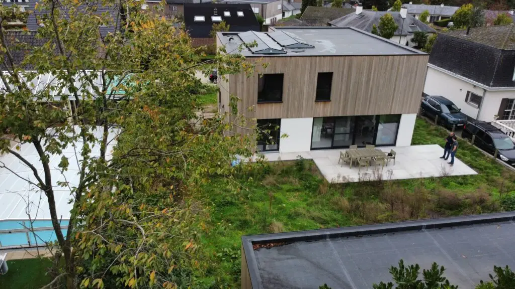 Dronebeeld van de achtergevel en platte daken van de gerenoveerde woning in Merelbeke