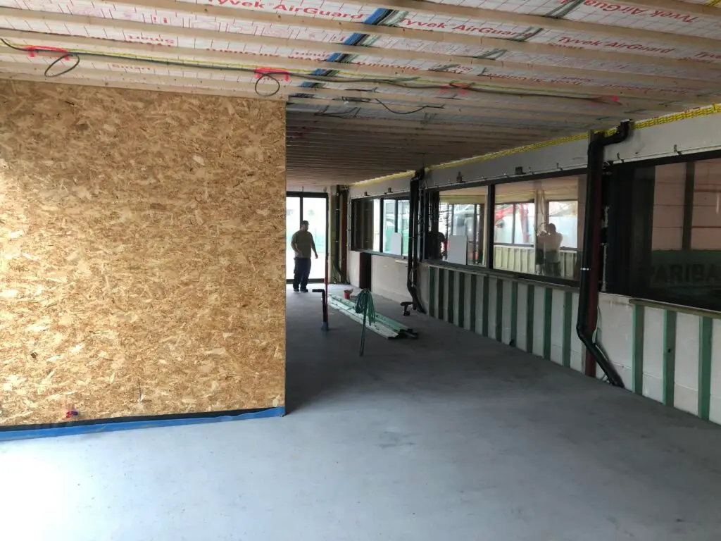 Binnenruimte van het clubhuis in Zottegem met OSB-wanden en zichtbare leidingen vóór de afwerking