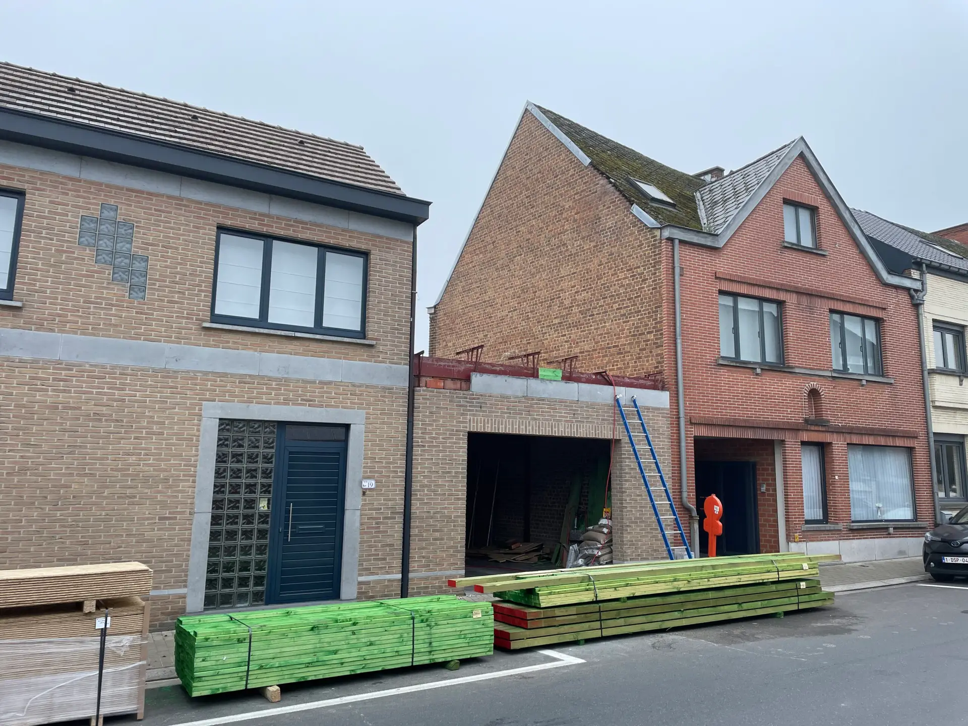 Bestaande garage tussen bakstenen woningen in Brakel, vóór de plaatsing van de extra verdieping